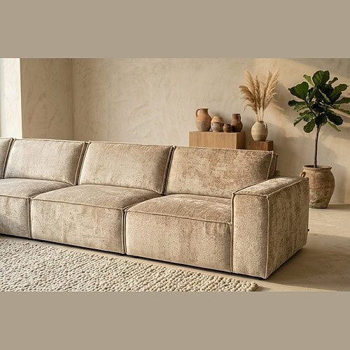 Elegante stoffen bank in een minimalistisch woonkamer met natuurlijke decoratie en planten, perfect voor een stijlvolle en comfortabele zithoek.
