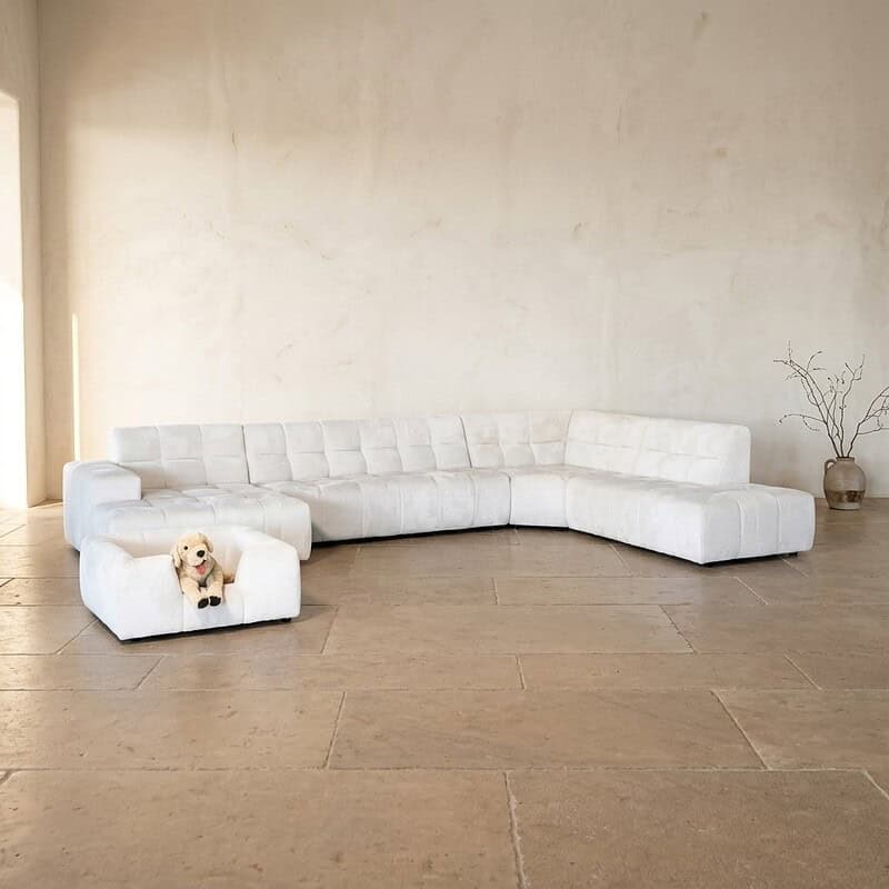 Bank met witte bekleding, modern design, geschikt voor gezellige zithoek, in een lichte, minimalistische woonkamer.