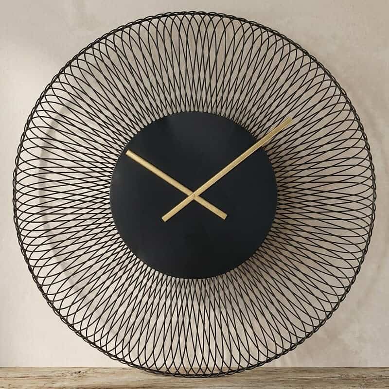 Moderne wandklok met zwart en goud accenten, omringd door een uniek draadpatroon, perfect voor een eigentijdse interieurstijl.