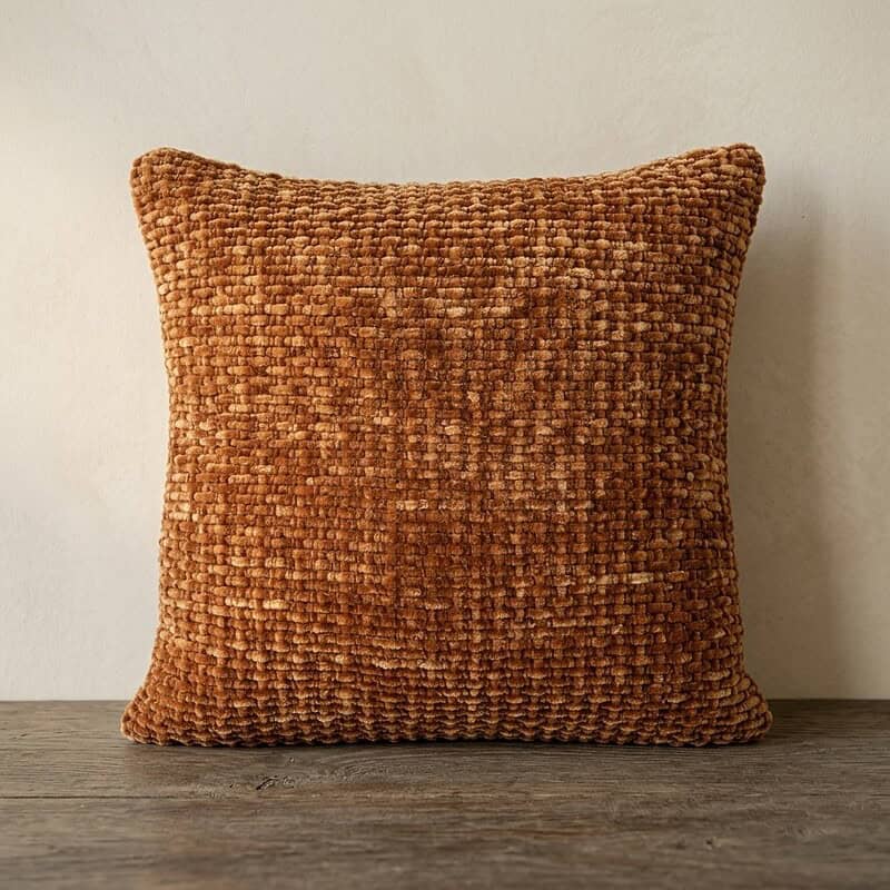 Decoratief kussen van Mokana meubelen met een warme, textuurrijke bekleding, perfect voor een gezellige zithoek of slaapkamer.