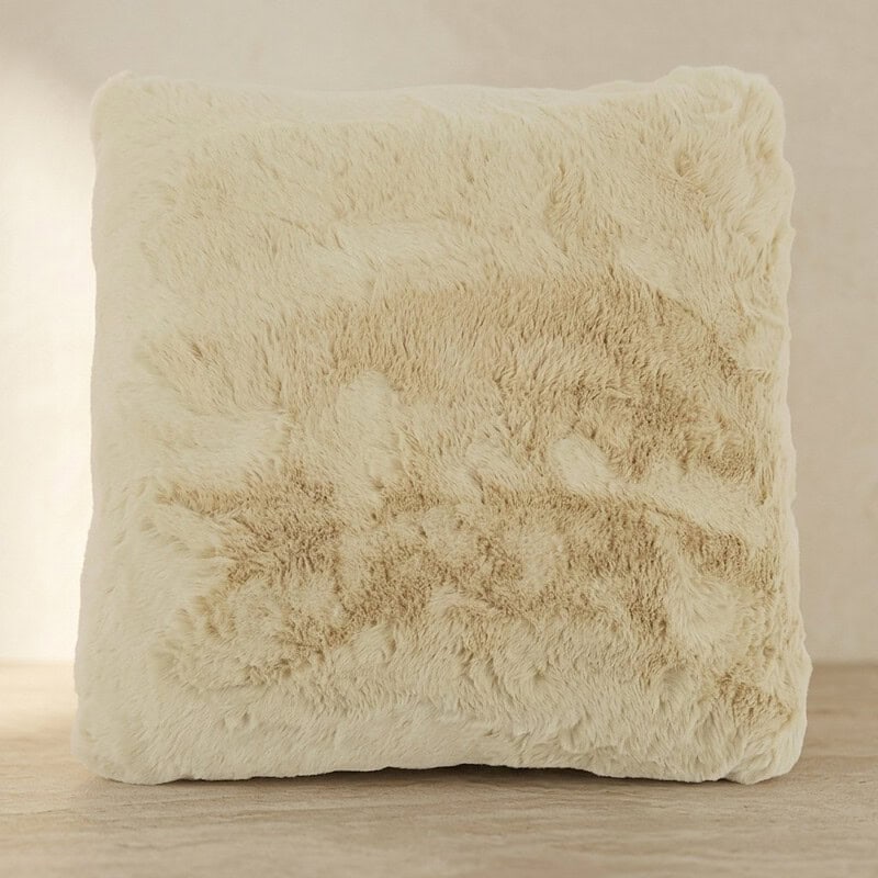 Luxe imitatiebont kussen in crèmekleur, perfect voor een gezellige en warme woonkamer, ideaal als decoratie of comfort toevoeging.