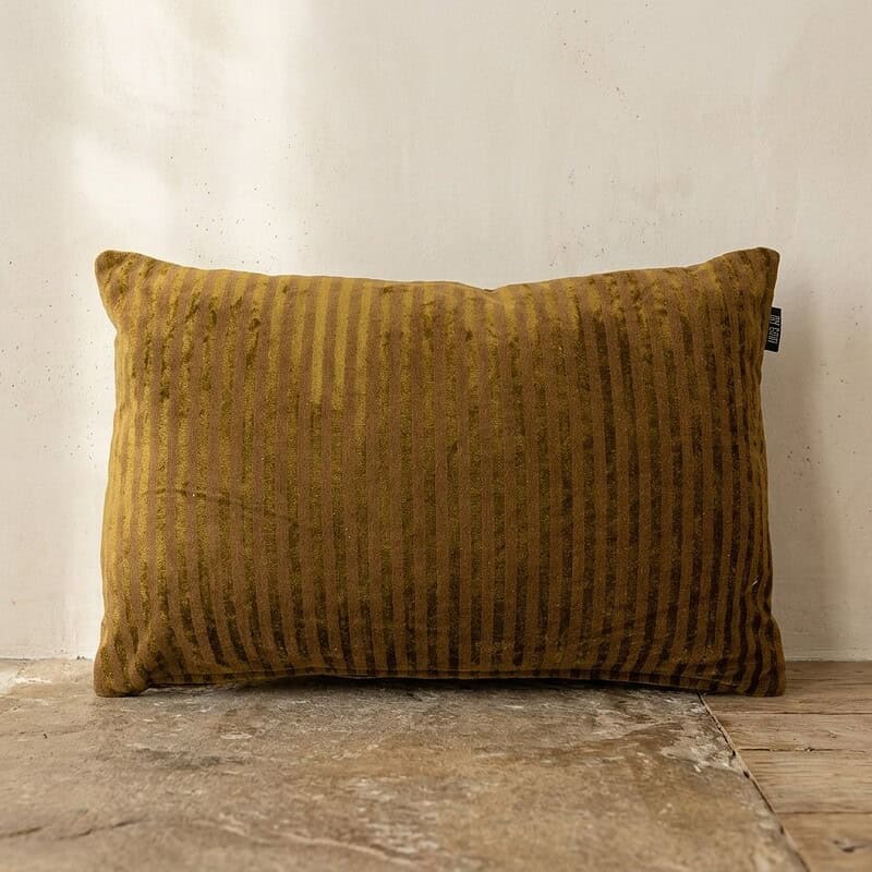 Luxe gouden gestreepte kussen op houten vloer, perfect voor modern interieur en comfortabele zithoek.