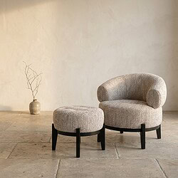 Luxe Mokana lounge stoel en bijpassende ottoman, modern design met zachte stoffen bekleding en zwarte houten poten, perfect voor stijlvolle zithoeken.