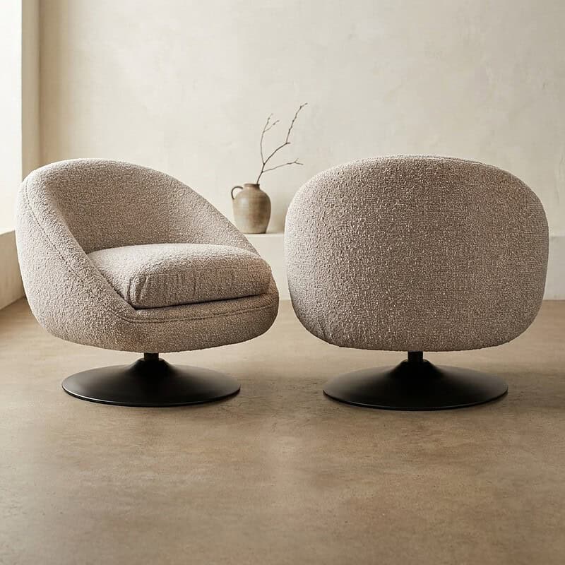 Zwei moderne, bequeme Loungesessel mit weicher Polsterung und runden Formen, platziert in einem minimalistischen Interieur. Perfekt für eine stilvolle und gemütliche Sitzecke.