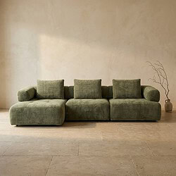 Bank met groene bekleding en kussens, minimalistisch interieur.