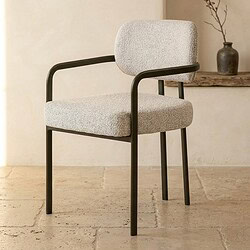 Moderne Mokana meubelstoel met comfortabele bekleding en zwart metalen frame, perfect voor een stijlvolle en gezellige zithoek.