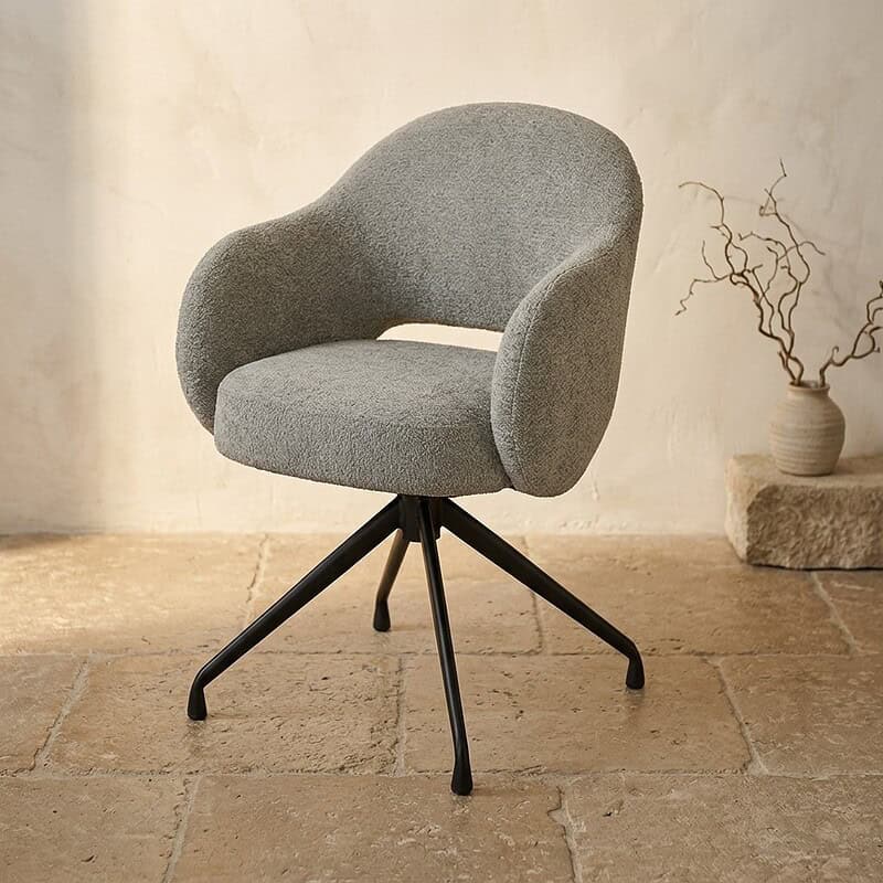 Moderne grijze fauteuil met comfortabele bekleding en zwarte metalen poten, perfect voor een stijlvolle woonkamer of kantoorruimte.