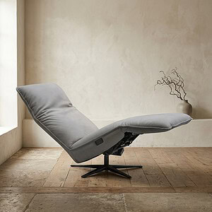 Relaxfauteuil met verstelbare rugleuning en voetsteun, perfect voor ontspanning en comfort in een strak, modern interieur.