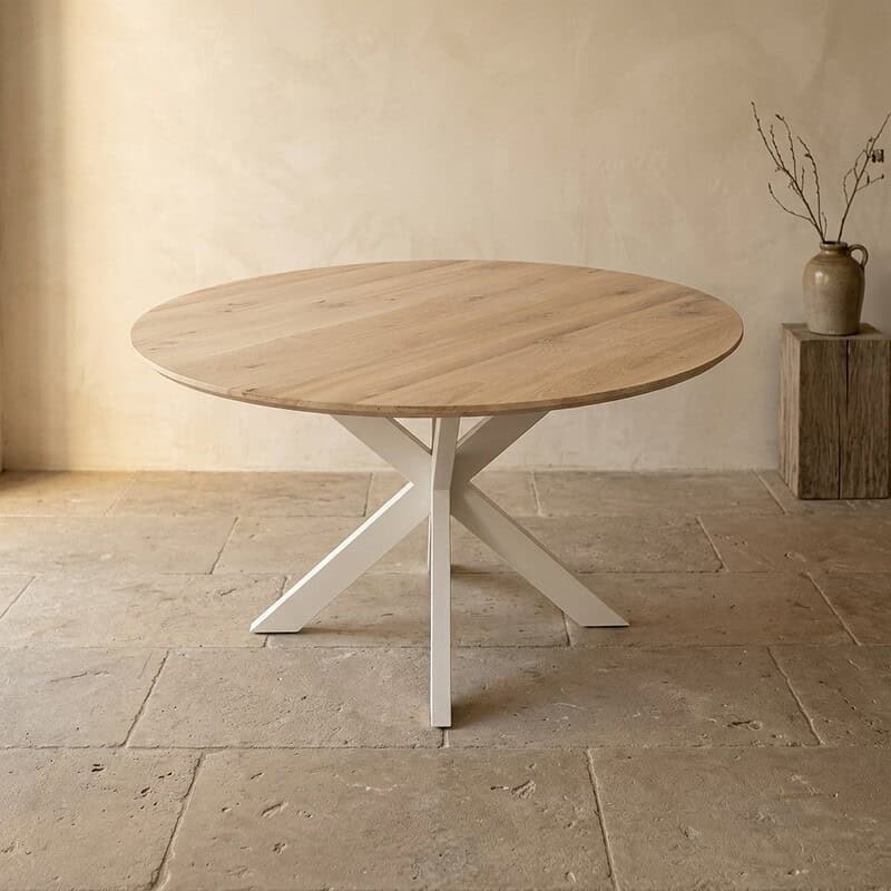 Moderne ronde eettafel met houten blad en wit onderstel, perfect voor een eigentijdse eetkamer of woonkamer.