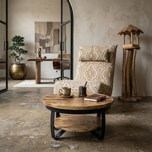 Sfeervol interieur met houten meubels, inclusief een ronde salontafel, een comfortabele armstoel met patroon, en natuurlijke decoraties in een industrieel interieur.