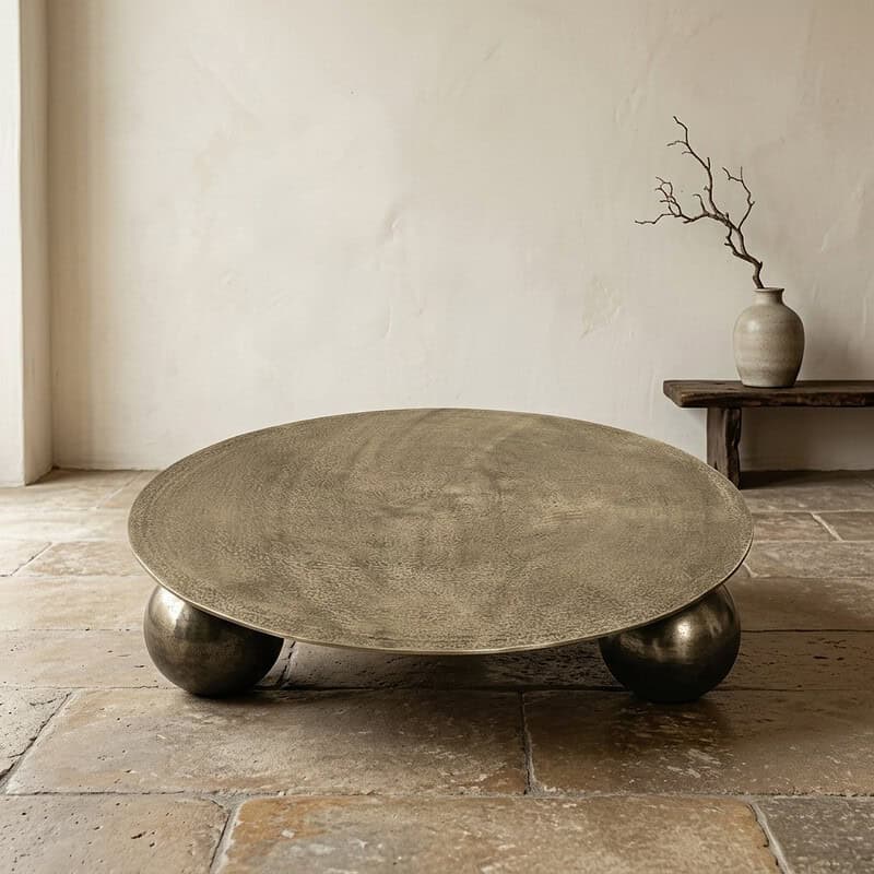 Moderne houten salontafel met ronde vorm en metalen bolpoten, perfect voor een eigentijdse woonkamer.