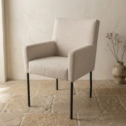 Moderne beige zitkamerstoel van Mokana met zachte bekleding en slanke zwarte poten, perfect voor een stijlvolle en comfortabele zithoek.
