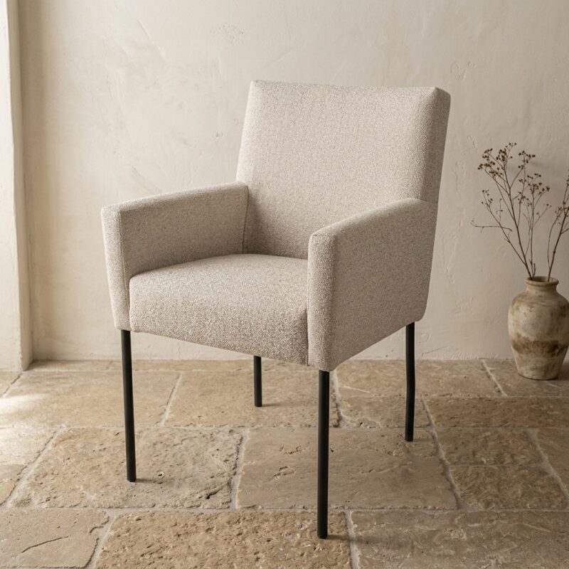 Moderne beige zitkamerstoel van Mokana met zachte bekleding en slanke zwarte poten, perfect voor een stijlvolle en comfortabele zithoek.