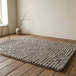 Luxe wollen knopen vloerkleed in neutrale grijstinten, perfect voor moderne woonkamers en slaapkamers. Handgemaakt, zacht en duurzaam, voegt warmte en stijl toe aan elk interieur.