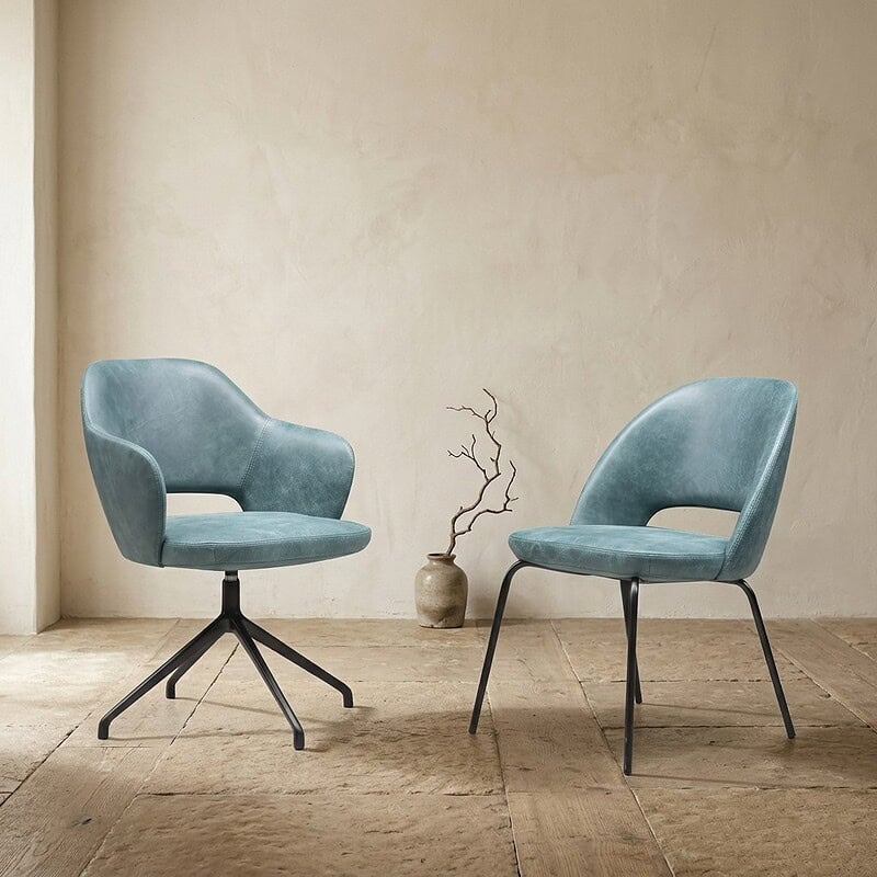 Moderne blauwe zitstoelen met elegante vormgeving en metalen poten, perfect voor een stijlvolle woonkamer inrichting.