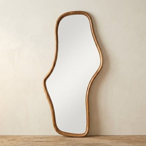 Houten spiegel met unieke vorm Unieke houten spiegel met een organische, golvende rand, perfect voor moderne interieurs en decoratie. Gemaakt van natuurlijk hout, voegt warmte en stijl toe aan elke ruimte.