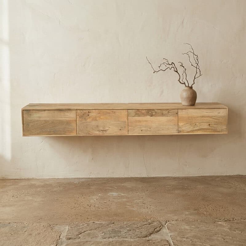 Strakke houten wandkast met vier lades, perfect voor een modern interieur, afgewerkt in natuurlijke houttinten, gecombineerd met een decoratieve vaas met takken.