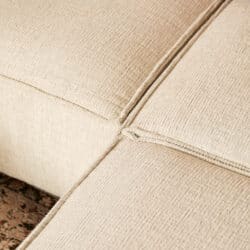 Close-up van een beige stoffen bank van Mokana Meubelen, met aandacht voor de textuur en afwerking.