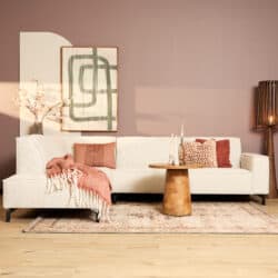 Moderne woonkamer met een beige bank, decoratieve kussens, een houten salontafel en kunst aan de muur, perfect voor een stijlvolle inrichting.
