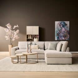 Moderne woonkamer met lichte bank, bijzettafels, kunstwerk en decoratieve elementen, perfect voor stijlvolle woonruimtes.