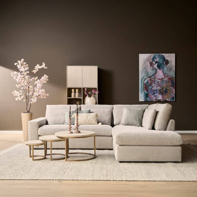 Moderne woonkamer met lichte bank, bijzettafels, kunstwerk en decoratieve elementen, perfect voor stijlvolle woonruimtes.