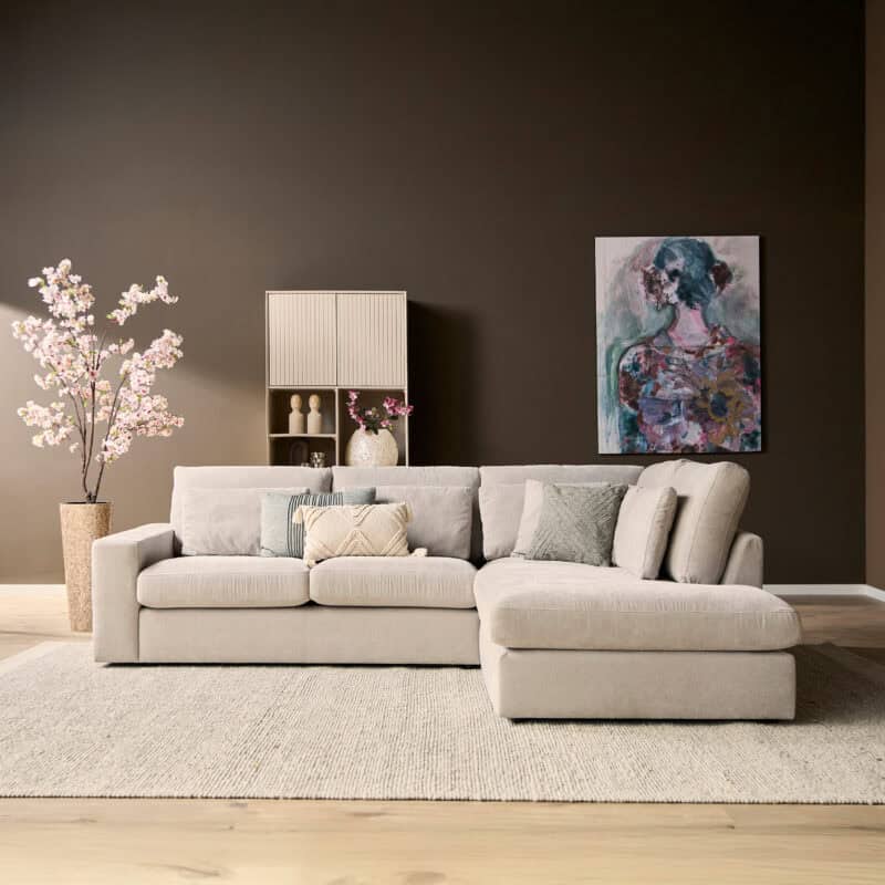 Moderne woonkamer met lichte bank, kunstwerk en decoratieve planten, perfect voor stijlvolle interieurs.
