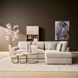 Moderne woonkamer met lichte bank, bijzettafels, kunstwerk en decoratieve planten, perfect voor stijlvolle woonruimtes.
