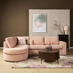 Luxe roze bank van Mokana Meubelen in een modern interieur met decoratieve accessoires en kunstwerk op de muur.