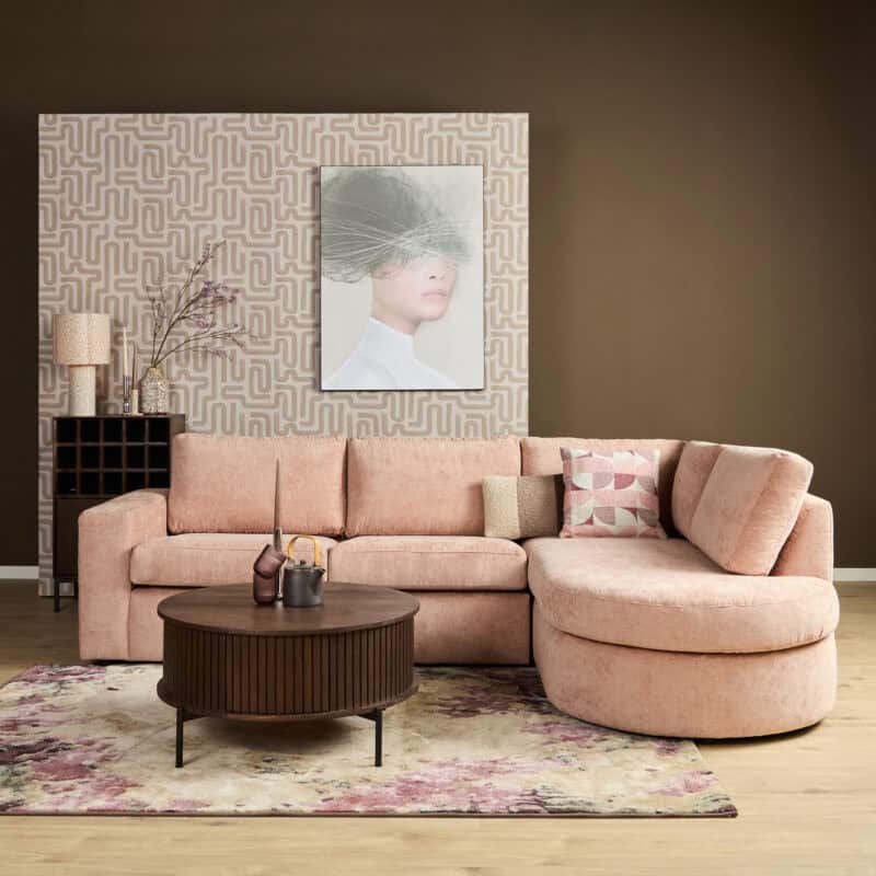 Luxe woonkamer met een roze bank, ronde salontafel en kunstwerk aan de muur, perfect voor moderne interieurs.