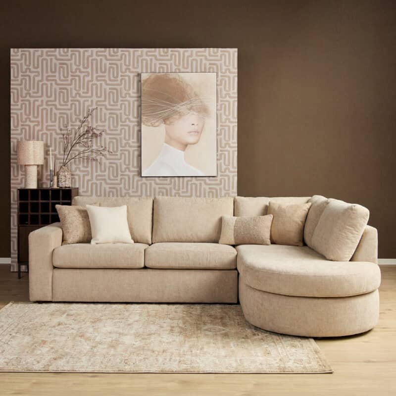 Luxe beige woonkamerbank van Mokana Meubelen met kussens en decoratieve elementen in een modern interieur.