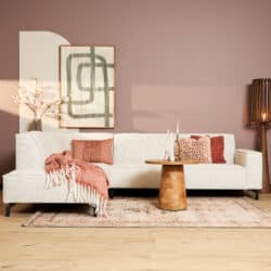 Luxe beige divan van Mokana Meubelen in een stijlvolle woonkamer met decoratieve elementen en zachte texturen.
