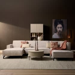 Moderne woonkamer met grote L-vormige bank, decoratieve kussens, kunstwerk en sfeerverlichting, perfect voor stijlvolle interieurs.