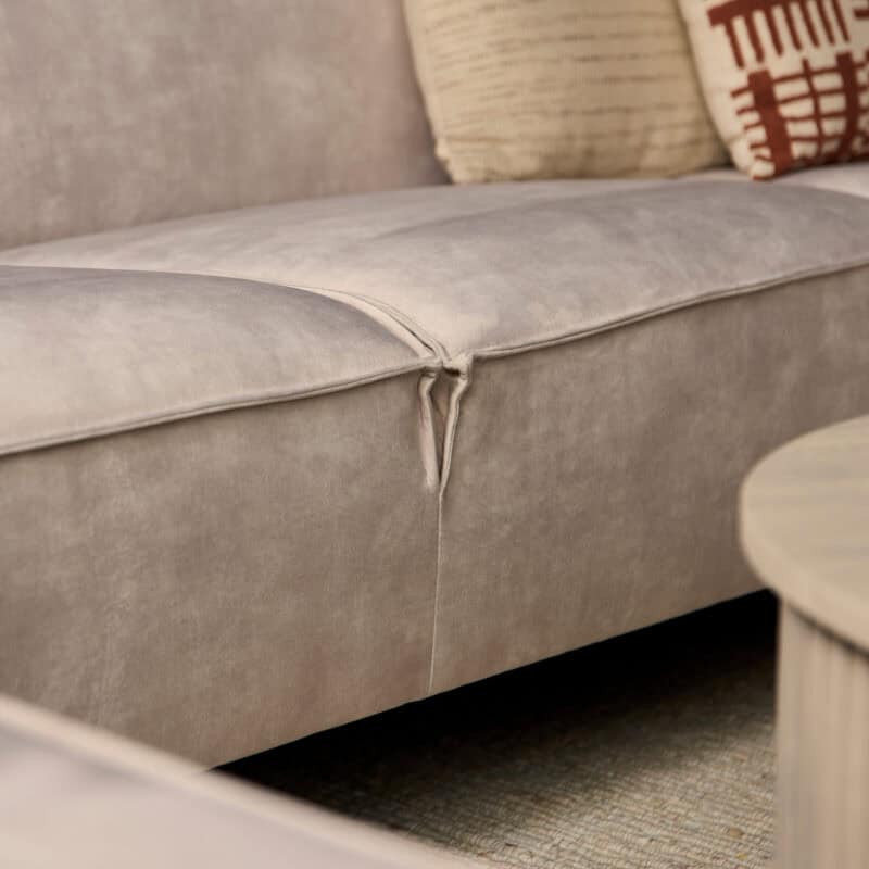 Dichtbijzicht van een lichte grijze lounge bank met een scheur in de bekleding, geschikt voor modern interieur.