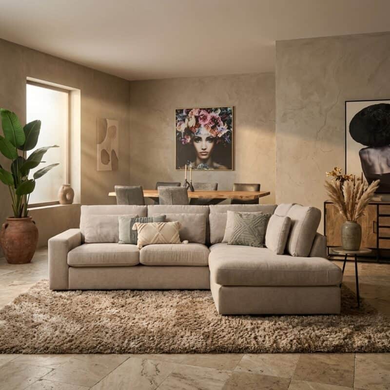 Luxe woonkamer ingericht met Mokana meubelen, inclusief een grote hoekbank, decoratieve kunstwerken en planten voor een stijlvolle uitstraling.